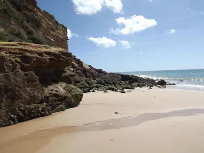 a sandy beach with rocks and the ocean at Burgau Ocean View Apartment in Burgau