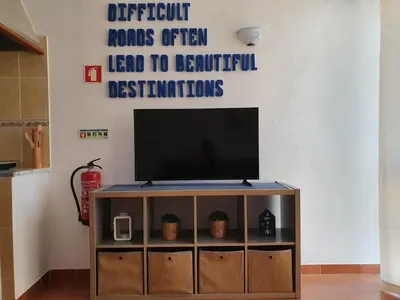 a television on a stand in a living room at Burgau Ocean View Apartment in Burgau