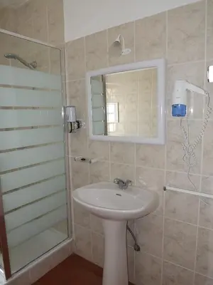 a bathroom with a sink and a shower with a mirror at Burgau Ocean View Apartment in Burgau