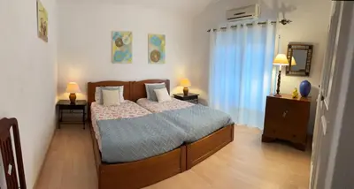 a bottle of wine and two glasses on a bed at Vivenda Romana - By Staywise in Lagos