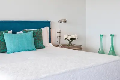 a bedroom with a white bed with a blue headboard at Villa Mar Azul in Salema