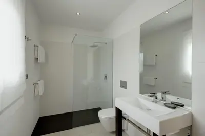 a white bathroom with a sink and a toilet at Villa Mar Azul in Salema