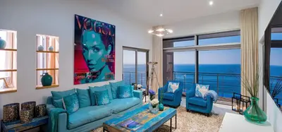 a living room with blue couches and a view of the ocean at Villa Mar Azul in Salema