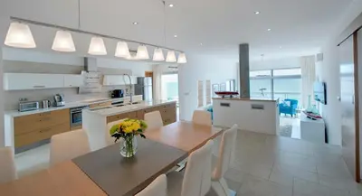 a kitchen and dining room with a table and chairs at Villa Mar Azul in Salema