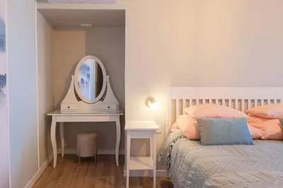 a bedroom with a bed and a table with a mirror at Ocean Bay Panoramic View in Funchal