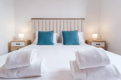 a bedroom with a large white bed with blue pillows at GuestReady - Serene Funchal Getaway in Funchal
