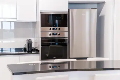 a kitchen with white cabinets and a stainless steel oven at GuestReady - Serene Funchal Getaway in Funchal