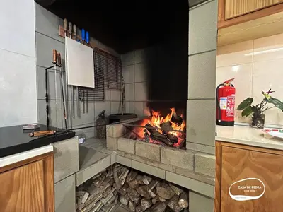 a fireplace in a kitchen with a fire place at Casa de Pedra AL in Ponta do Pargo