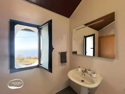 a bathroom with a sink and a window at Casa de Pedra AL in Ponta do Pargo