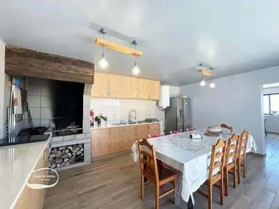 a kitchen with a table and chairs in a room at Casa de Pedra AL in Ponta do Pargo