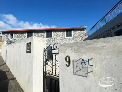 a building with a gate with the number art on it at Casa de Pedra AL in Ponta do Pargo