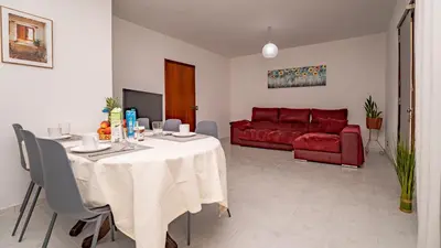 a living room with a table and a red couch at Casa Conceição in Ribeira Brava