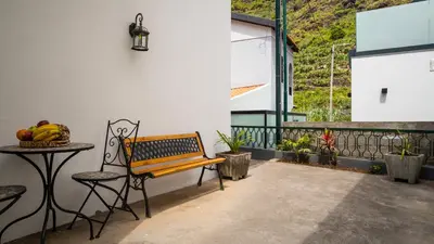 a bench and a table on a patio at Casa Conceição in Ribeira Brava