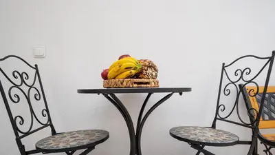 a table with a basket of fruit and two chairs at Casa Conceição in Ribeira Brava