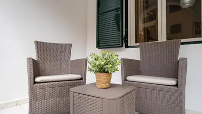 two wicker chairs and a table with a plant on it at Casa Conceição in Ribeira Brava