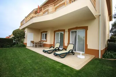 a house with two chairs and a balcony at Apartamento Boavista Golf Resort by Algarving in Lagos