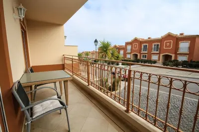 a balcony with a table and a chair and a street at Apartamento Boavista Golf Resort by Algarving in Lagos