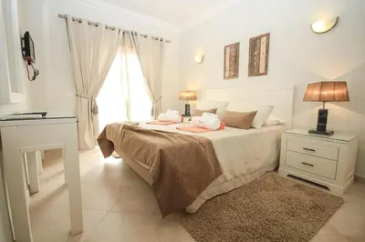 a white bedroom with a bed and a window at Apartamento Boavista Golf Resort by Algarving in Lagos
