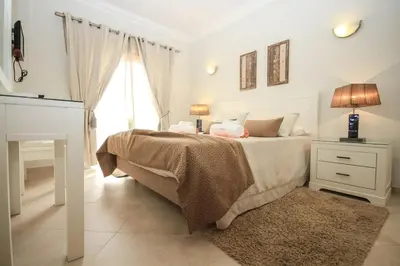 a white bedroom with a bed and a window at Apartamento Boavista Golf Resort by Algarving in Lagos