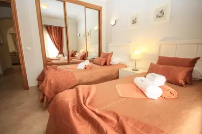 a hotel room with two beds and a mirror at Apartamento Boavista Golf Resort by Algarving in Lagos