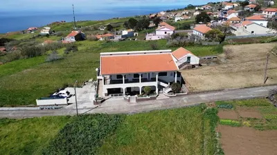 a house with an orange roof on a hill at Casa do Prendinha A in Ponta do Pargo