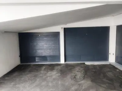 a room with two large windows with black garage doors at Funchal Infinito Azul - Moderno elegante com piscina in Funchal