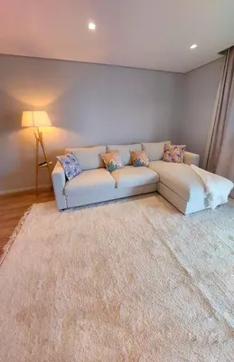 a white couch in a living room with a rug at Funchal Infinito Azul - Moderno elegante com piscina in Funchal