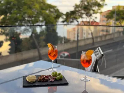 two wine glasses and a plate of food on a table at Funchal Infinito Azul - Moderno elegante com piscina in Funchal
