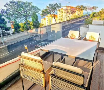 a table and chairs on top of a balcony at Funchal Infinito Azul - Moderno elegante com piscina in Funchal