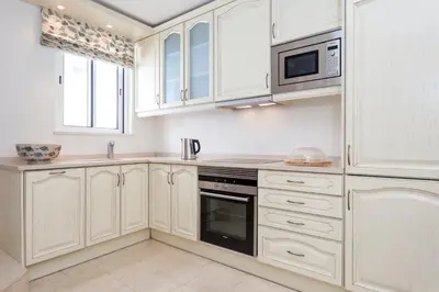 a kitchen with white cabinets and a microwave at Residence Estrela do Mar in Salema