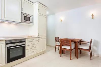 a kitchen with a table and chairs and a microwave at Residence Estrela do Mar in Salema