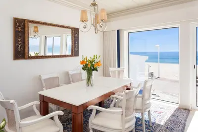 a dining room with a table and chairs and a mirror at Residence Estrela do Mar in Salema
