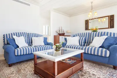 a living room with two blue couches and a coffee table at Residence Estrela do Mar in Salema
