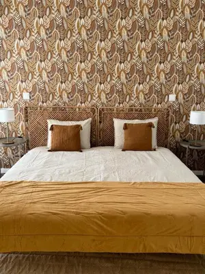 a bed with two pillows in a bedroom with a wallpaper at Stay In Virtudes II in Funchal
