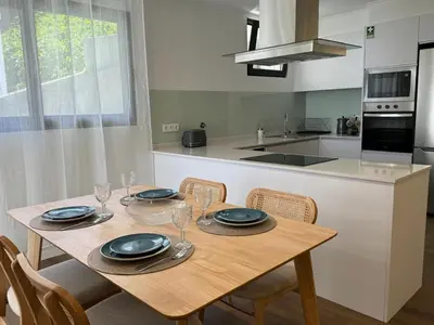 a kitchen with a wooden table with four chairs and a table at Stay In Virtudes II in Funchal