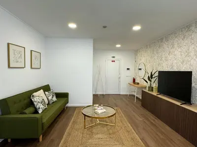 a living room with a green couch and a television at Stay In Virtudes II in Funchal