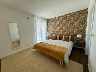 a bedroom with a large bed and a mirror at Stay In Virtudes II in Funchal
