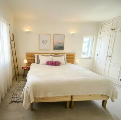 a bedroom with a large white bed with two pillows at 2 minutes walk to the beach Praia da Luz - Casa da Maria in Luz
