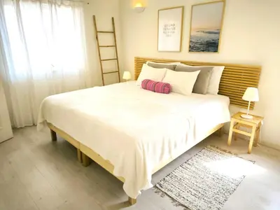 a bedroom with a large white bed and a window at 2 minutes walk to the beach Praia da Luz - Casa da Maria in Luz