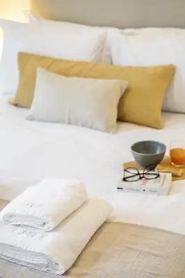 a bed with white pillows and a bowl on it at Zino Apartment A - By Wehost in Funchal