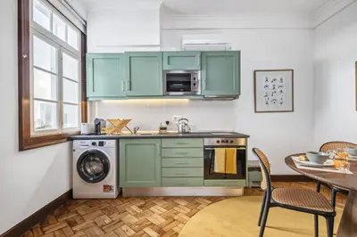 a kitchen with green cabinets and a table at Zino Apartment A - By Wehost in Funchal