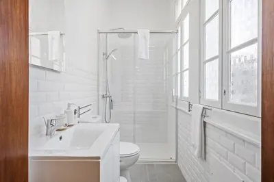 a white bathroom with a sink and a shower at Zino Apartment A - By Wehost in Funchal