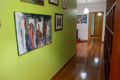 a hallway with a green wall with paintings on it at BiBel Apartment in Funchal