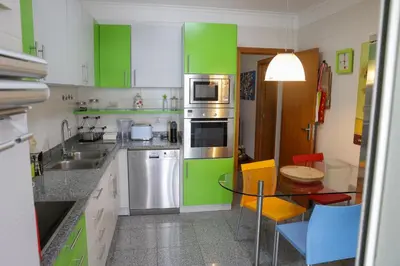 a kitchen with green cabinets and a glass table at BiBel Apartment in Funchal