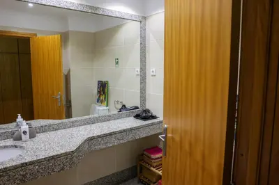 a bathroom with a sink and a large mirror at BiBel Apartment in Funchal