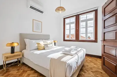 a bedroom with a bed with white sheets and a window at Zino Apartment B - By Wehost in Funchal