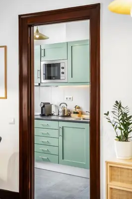 a kitchen with green cabinets and a microwave at Zino Apartment B - By Wehost in Funchal