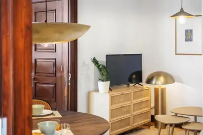 a living room with a table and a tv at Zino Apartment B - By Wehost in Funchal