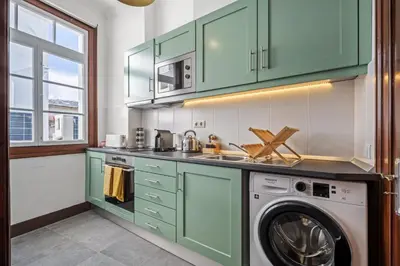 a kitchen with green cabinets and a washer and dryer at Zino Apartment B - By Wehost in Funchal