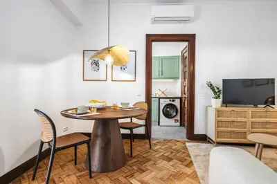 a living room with a table and chairs and a television at Zino Apartment B - By Wehost in Funchal